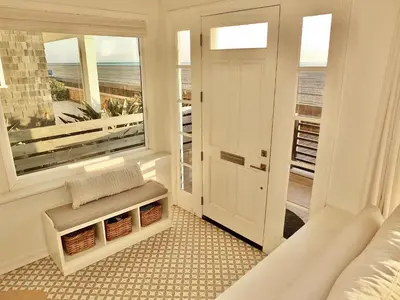 a room with a bed and a window with a view of the ocean at Beachfront Estate - LB Peninsula in Long Beach
