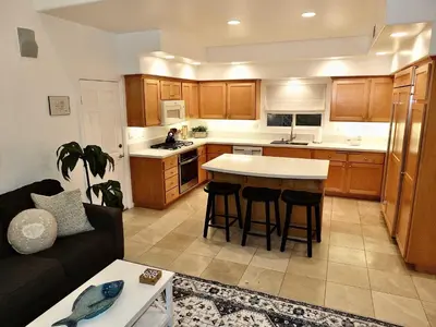 a living room with a couch and a kitchen at Beauty by the Beach - SoCal Fun in Long Beach