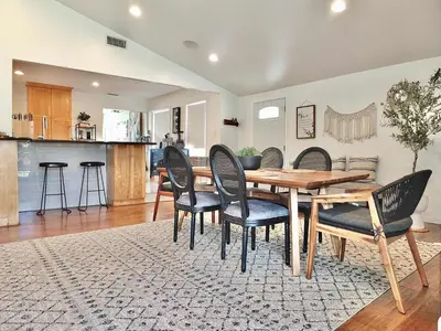 a dining room with a wooden table and chairs at Bellflower Breeze - Charming 3 BDR in Long Beach in Long Beach
