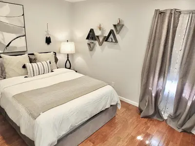 a bedroom with a large bed and a window at Bellflower Breeze - Charming 3 BDR in Long Beach in Long Beach