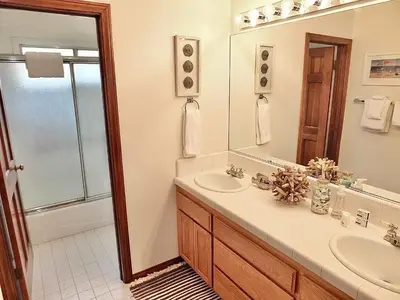a bathroom with a sink and a shower and a mirror at Belmont Heights Retreat - Stunning Gardens in Long Beach