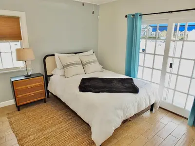 a bedroom with a bed with a black pillow on it at Belmont Shore Beach House - Incredible Oceanfront Views in Long Beach