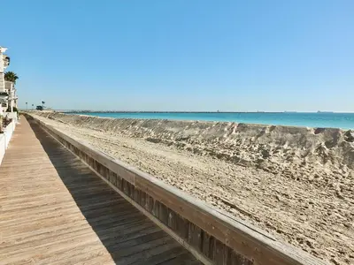 a boardwalk on a beach next to the ocean at Steps to Beach & Alamitos Bay on LB Peninsula in Long Beach