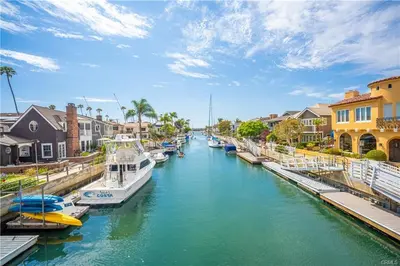 a group of boats docked in a river with houses at Steps to Beach & Alamitos Bay on LB Peninsula in Long Beach