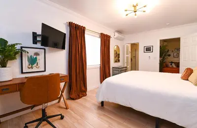 a bedroom with a bed and a desk and a television at Immaculate 3BDR Bungalow - 5-Min Walk to Beach in Long Beach