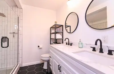 a bathroom with a sink and a toilet and a mirror at Immaculate 3BDR Bungalow - 5-Min Walk to Beach in Long Beach