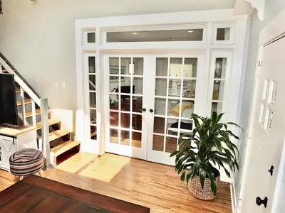 a living room with a door and a potted plant at Park Avenue Beach Paradise - Chic & Secluded 4 BDR in Long Beach