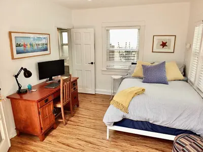 a bedroom with a bed and a desk with a computer at Park Avenue Beach Paradise - Chic & Secluded 4 BDR in Long Beach