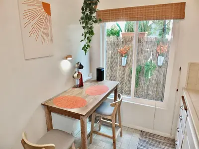 a kitchen with a wooden table and chairs and a window at Sand Sun & Second - Charming Studio within Walking Distance to Beach in Long Beach