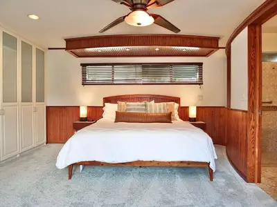 a bedroom with a large bed and a ceiling fan at The Belmont Beach Bungalow - Pool & Hot tub in Long Beach