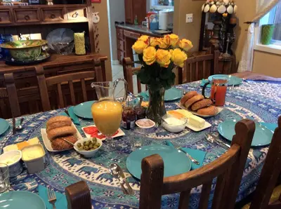 a table with a blue table cloth with food and flowers at Sweet Dreams B&B LA in Sherman Oaks