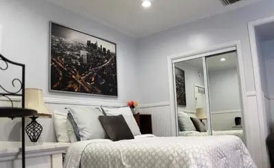 a white bedroom with a bed and a mirror at Sweet Dreams B&B LA in Sherman Oaks