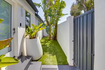 a courtyard with plants and a white fence at Walk to Sunset Strip Modern Home in WeHo Hills! in Los Angeles