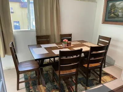 a dining room table with wooden chairs and a table and a table at Cozy 2 BR Apartment Glendale in Glendale