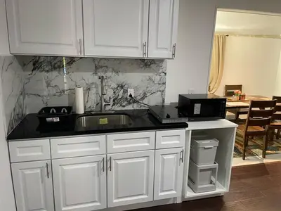 a kitchen with white cabinets and a sink at Cozy 2 BR Apartment Glendale in Glendale