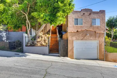 a building with a gate and a white garage at 5 Mi to Dtwn Los Angeles Apt with Outdoor Space! in Los Angeles