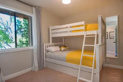 a bedroom with bunk beds and a ladder at Love Bug by Funtierland Vacation Rentals in Anaheim
