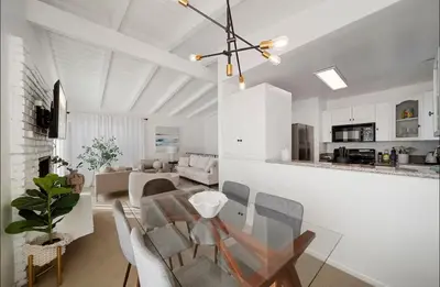 a dining room and living room with a table and chairs at Steps to Sand Cozy 3BR Partial Ocean Views in Manhattan Beach