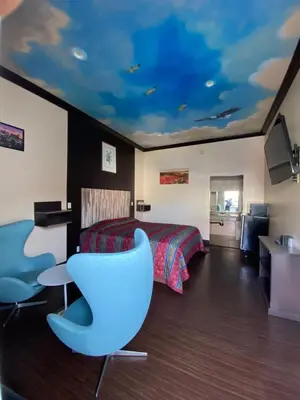 a bedroom with a bed and a blue chair at Dream Inn in Inglewood