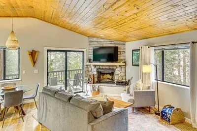 a living room with a couch and a fireplace at 2 Mi to Lake Arrowhead Treetop Retreat with Deck in Lake Arrowhead