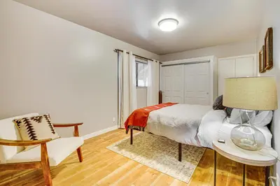a bedroom with a bed and a chair and a table at 2 Mi to Lake Arrowhead Treetop Retreat with Deck in Lake Arrowhead