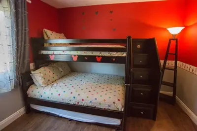 a childs bunk bed in a room with a red wall at Radiator Springs by Funtierland Vacation Rentals in Anaheim