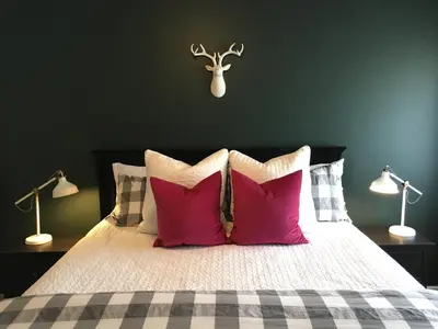 a bedroom with a bed with red pillows and two lamps at Arendelle by Funtierland Vacation Rentals in Anaheim