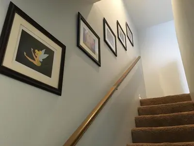 a stairway with framed pictures on the wall at Arendelle by Funtierland Vacation Rentals in Anaheim