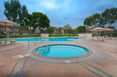 a large swimming pool with benches around it at Pixie Hollow by Funtierland Vacation Rentals in Anaheim