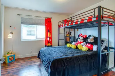 two stuffed animals sitting on a bed in a bedroom at Maleficents Retreat by Funtierland Vacation Rentals in Anaheim