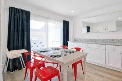 a kitchen with a white table and red chairs at New Suite Escapes 6 by Funtierland Vacation Rentals in Anaheim
