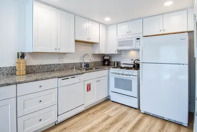 a kitchen with white cabinets and a white refrigerator at New Suite Escapes 6 by Funtierland Vacation Rentals in Anaheim