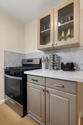a kitchen with a black stove and white cabinets at Hollywood Glam Hideaway - Steps to Walk of Fame in Los Angeles