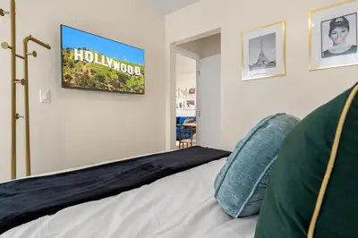 a bedroom with a bed with a sign on the wall at Hollywood Glam Hideaway - Steps to Walk of Fame in Los Angeles
