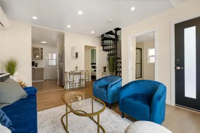 a living room with two blue chairs and a table at Hollywood Glam Hideaway - Steps to Walk of Fame in Los Angeles