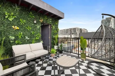 a balcony with a couch and a green wall at Hollywood Glam Hideaway - Steps to Walk of Fame in Los Angeles