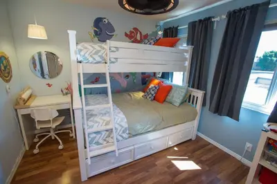 a white bunk bed in a room with a desk at Bedknobs and Broomsticks by Funtierland Vacation Rentals in Anaheim