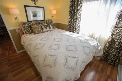 a bedroom with a large white bed with a window at Bedknobs and Broomsticks by Funtierland Vacation Rentals in Anaheim