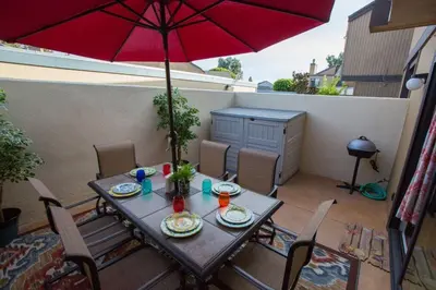 a table with a red umbrella on a patio at Under the Sea by Funtierland Vacation Rentals in Anaheim