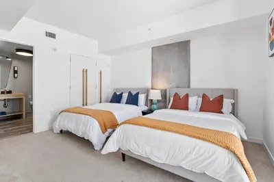 two beds in a bedroom with white walls at Rooftop Pool Modern 2BR, 2BA - Panoramic Hollywood views in Los Angeles