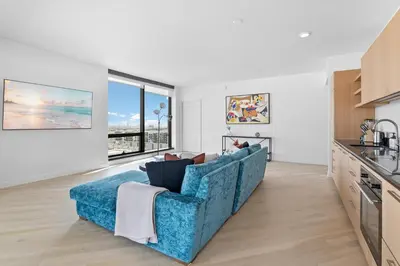 a living room with a blue couch in a kitchen at Rooftop Pool Modern 2BR, 2BA - Panoramic Hollywood views in Los Angeles