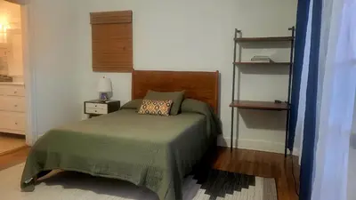 a bedroom with a bed with a green bedspread at Charming Studio Four with Private Patio in Los Angeles