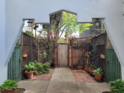 an entrance to a wooden fence with potted plants at Charming Studio Four with Private Patio in Los Angeles