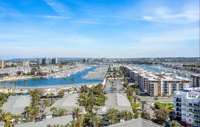 a view of a harbor with palm trees and buildings at Oceanfront Bliss, Beach & Marina Views, Roomy 1BR in Los Angeles