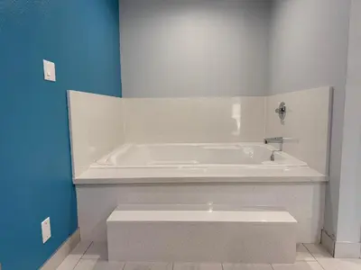 a white tub in a bathroom with a blue wall at Royale Inn \u8001\u723a\u5ba2\u68e7 - San Gabriel, Los Angeles in Rosemead