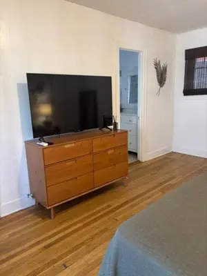 a living room with a large television on a dresser at Cozy Apartment Two in Hollywood! in Los Angeles