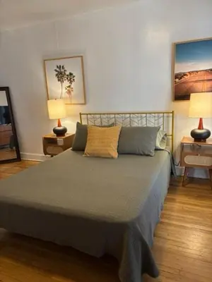 a bedroom with a bed with two lamps on two tables at Cozy Apartment Two in Hollywood! in Los Angeles