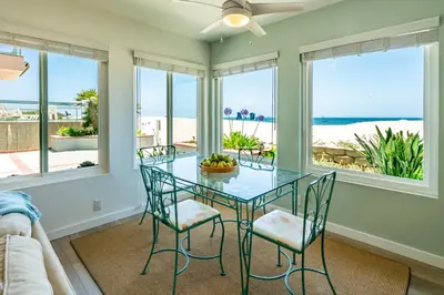 a dining room with a glass table and chairs at Carpinteria Dreamin by Paradise Retreats in Carpinteria
