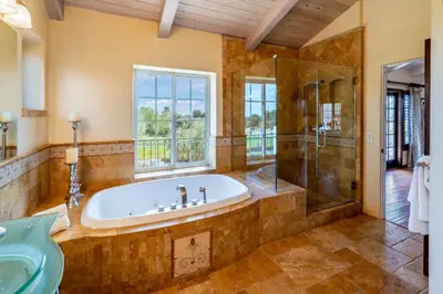 a bathroom with a tub and a shower and a window at Casa Tranquility by Paradise Retreats in Carpinteria