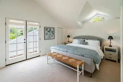 a bedroom with a large bed and a window at Ocean Breeze Abode and Bungalow by Paradise Retreats in Summerland